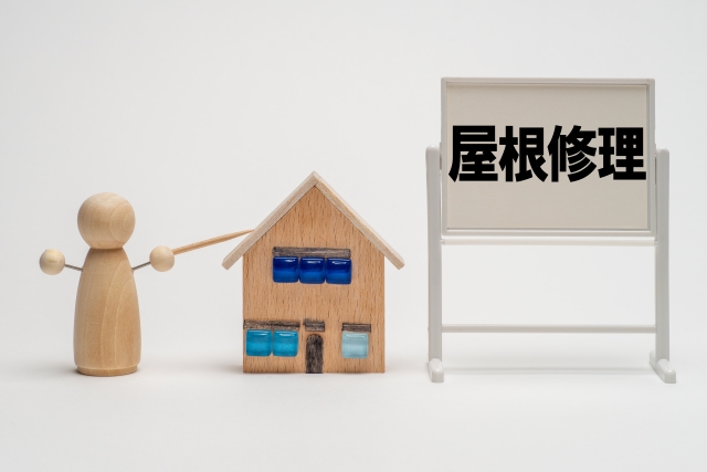 家の模型と屋根修理の文字